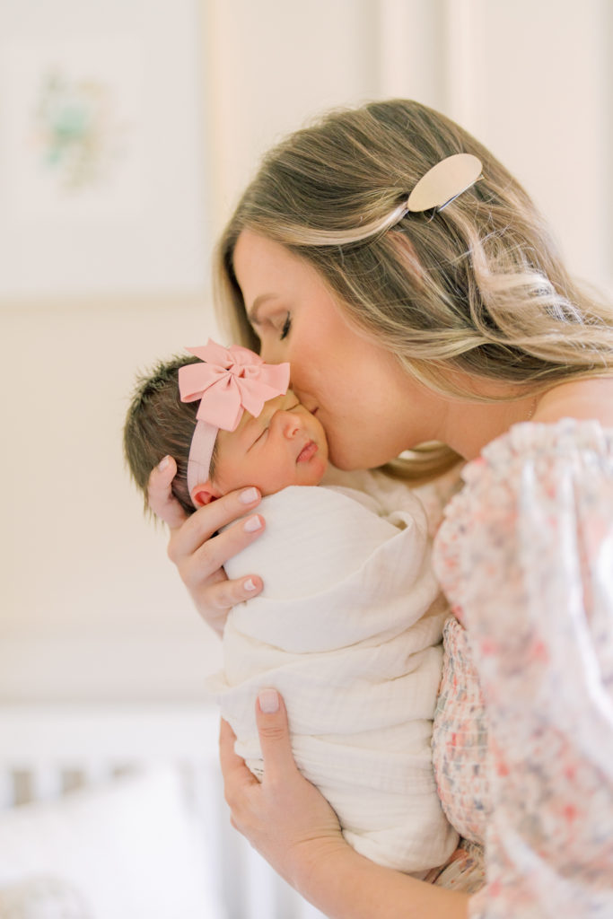 Winston Salem Newborn Photographer Mom kisses baby during newborn session